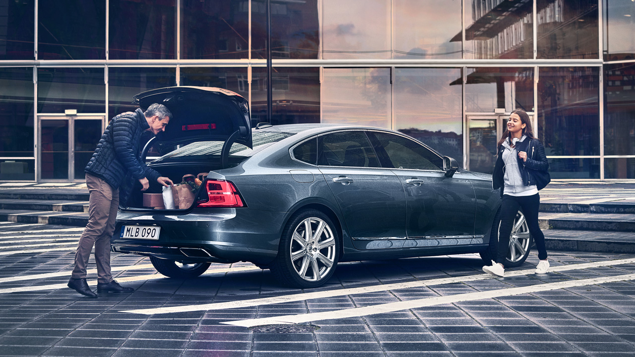 Father packing Volvo trunk with daughter