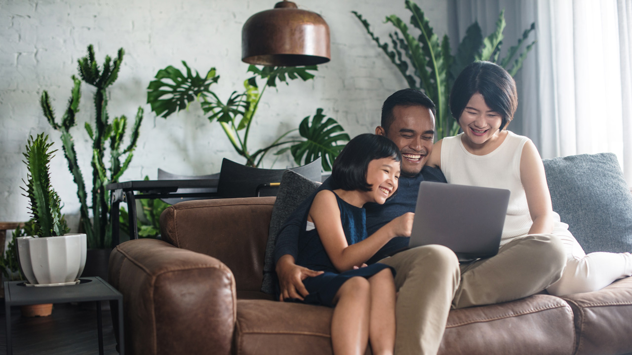 Happy family on couch with laptop