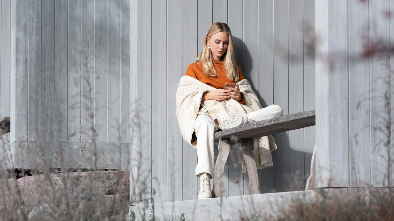 Volvo lifestyle woman sitting on bench with phone
