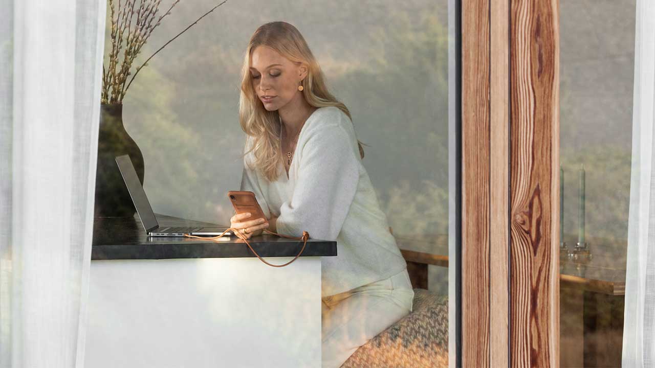 Woman on laptop and phone making duplicate requests