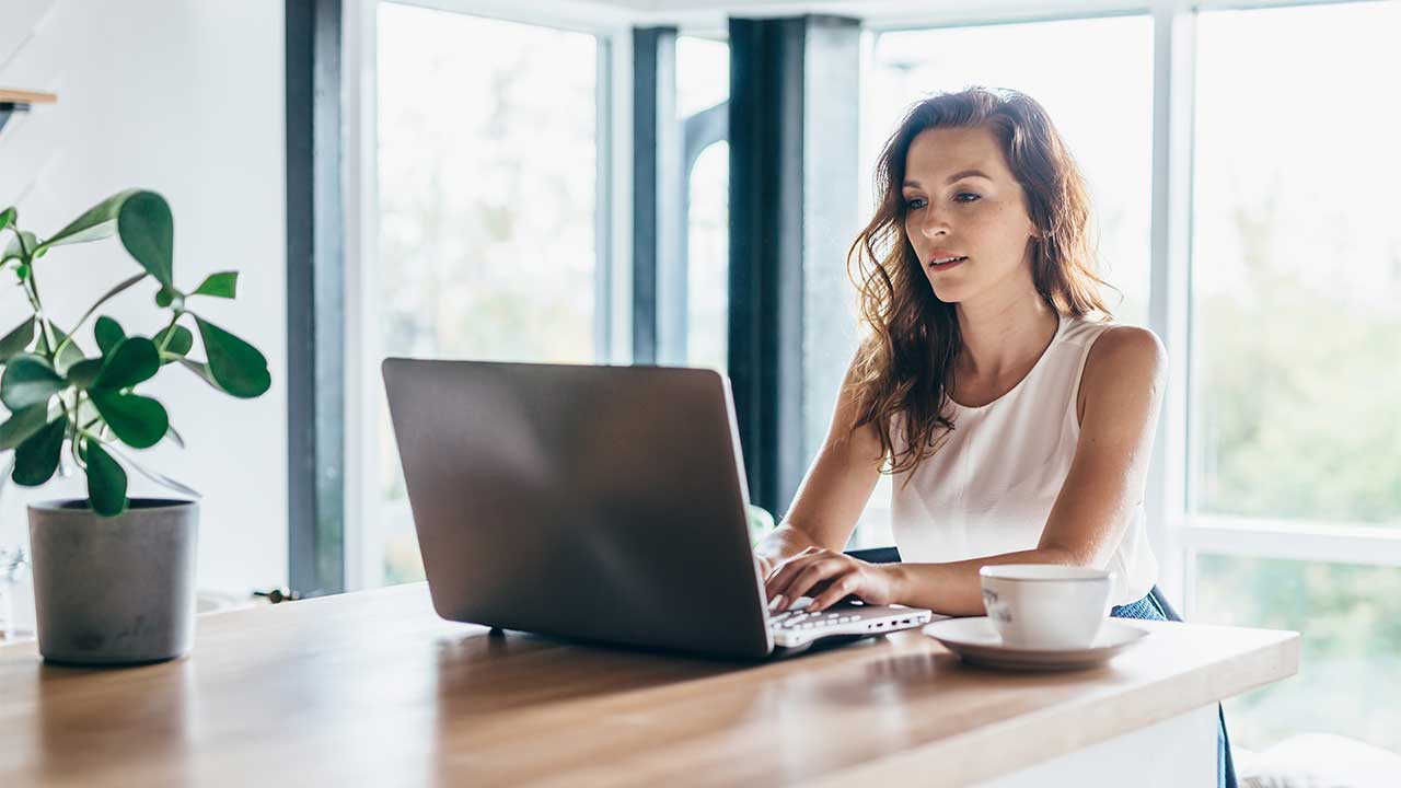 woman using laptop in a bright kitchen