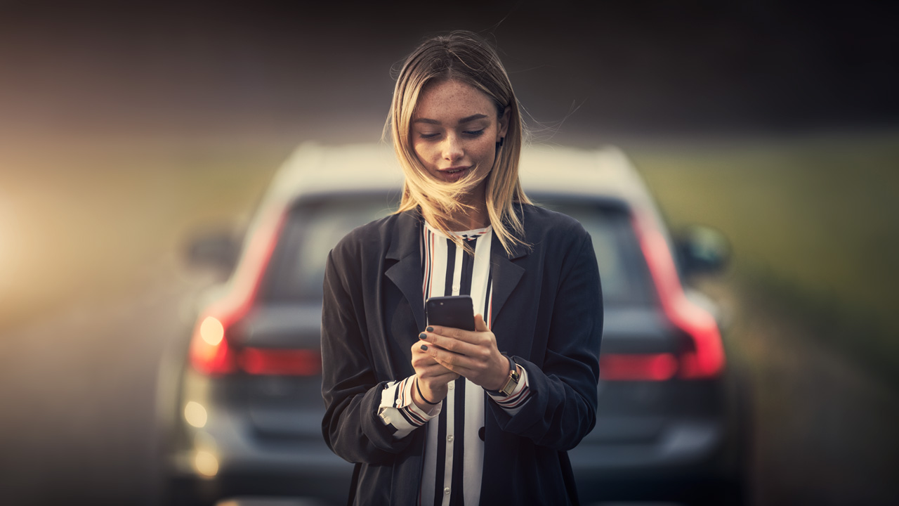 Blond woman behind Volvo with phone