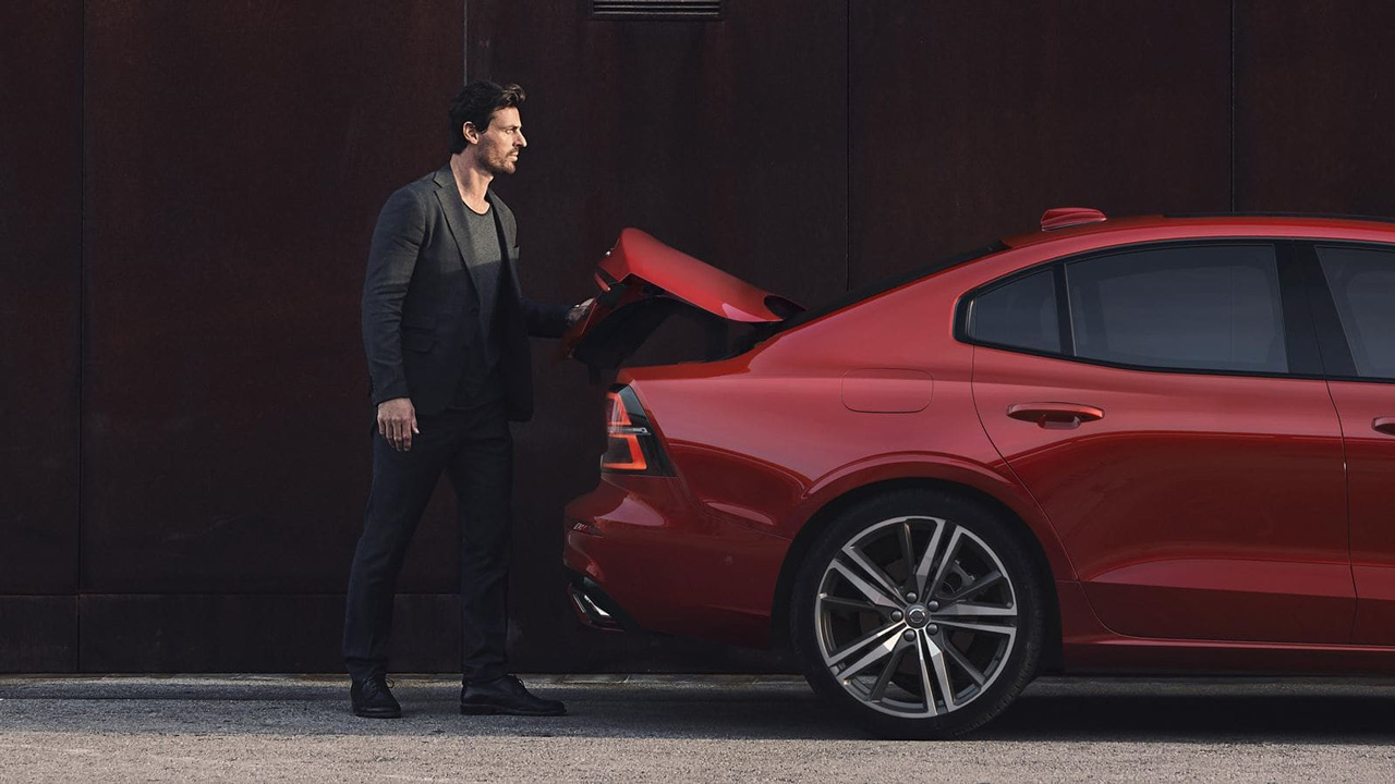 Red S60 with man opening trunk