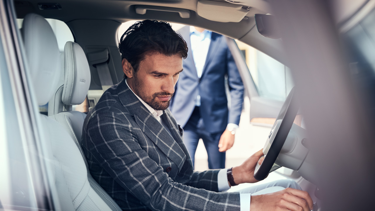 Man in plaid suit inside Volvo