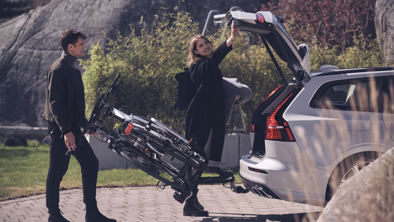 Couple packing golf equipment in trunk